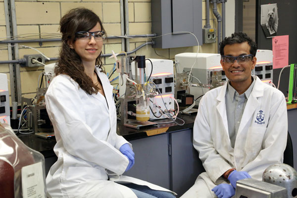 Chemical engineering PhD candidate Kayla Nemr and Professor Krishna Mahadevan grow yeast in a bioreactor. Along with their collaborators, they are using these organisms to transform bark, leaves and stems into the chemical building blocks of materials such as nylon. (Photo: Tyler Irving)