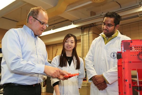 Professor Hani Naguib (MIE, MSE) and mechanical engineering students Ali Anwer and Vina Hui discuss their research into advanced manufacturing techniques. (Photo: Kevin Soobrian)