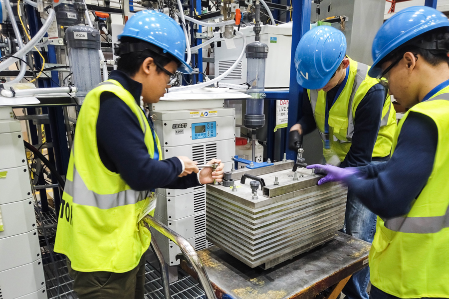 CERT team members work on a pilot-scale electrolyzer at Zeton Engineering in Burlington, Ont. (Photo: Christine Gabardo)