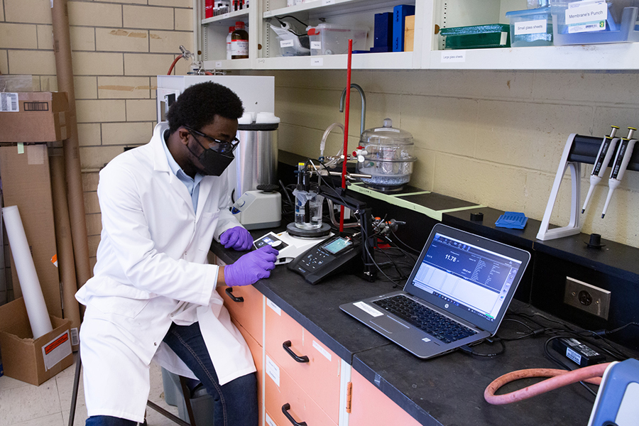 Oseremen Ebewele (ChemE MASc candidate) monitors a system that takes CO2 from the air and dissolves it into a solution. (Photo: Tyler Irving)