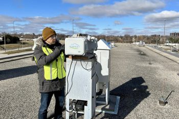 A research installs an air monitoring system on a rooftop.