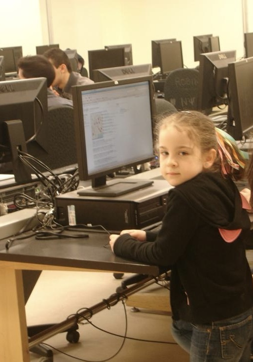 A young Taleen is seen in front of a desktop computer in an engineering computer lab at U of T.