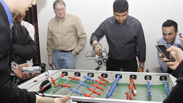 Students use their created LEGO forearm prosthetics to compete in a game of foosball.