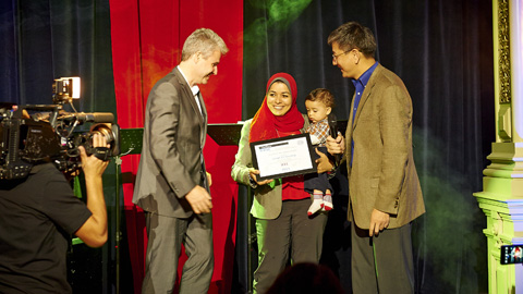 U of T Civil Engineering graduate Samah El-Tantawy, holding her son Yusuf, receives her first-place IEEE ITSS award