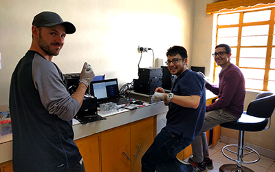 From left: Christian Fobel, Alphonsus Ng, and Julian Lamanna running blood tests on the MR box instruments in their temporary lab in one of the Kakuma health clinics. (Credit: Ryan Fobel)
