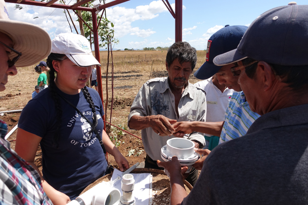 Anna Jiang (MIE MASc candidate) demonstrates her passive water controller for community members in Pedro Arauz, Nicaragua. The device is designed to help farmers make more efficient use of irrigation water. (Image courtesy Anna Jiang)