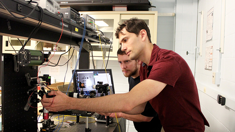 U of T doctoral researchers Iliya Sigal (right) and Dene Ringuette are part of a team that designed a miniature microscope that could open new doors for epilepsy and seizure monitoring and treatment. (Credit: Luke Ng).