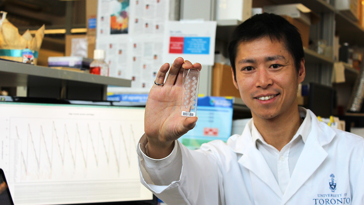 Stanley Ng (IBBME) holds up a cartridge used to measure the gene expression levels of cancer cells. A team led by Ng has developed a new rapid test that can predict the effectiveness of leukemia treatments for a given patient, providing results in 24 to 48 hours. Photo: Luke Ng
