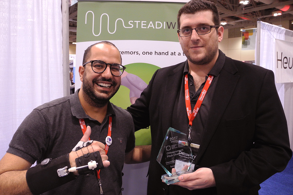 Emile Maamary and Mark Elias (CivE 1T4) show off Steadiwear's tremor-dampening glove and the startup's latest award. (Photo: Chris Sorensen)