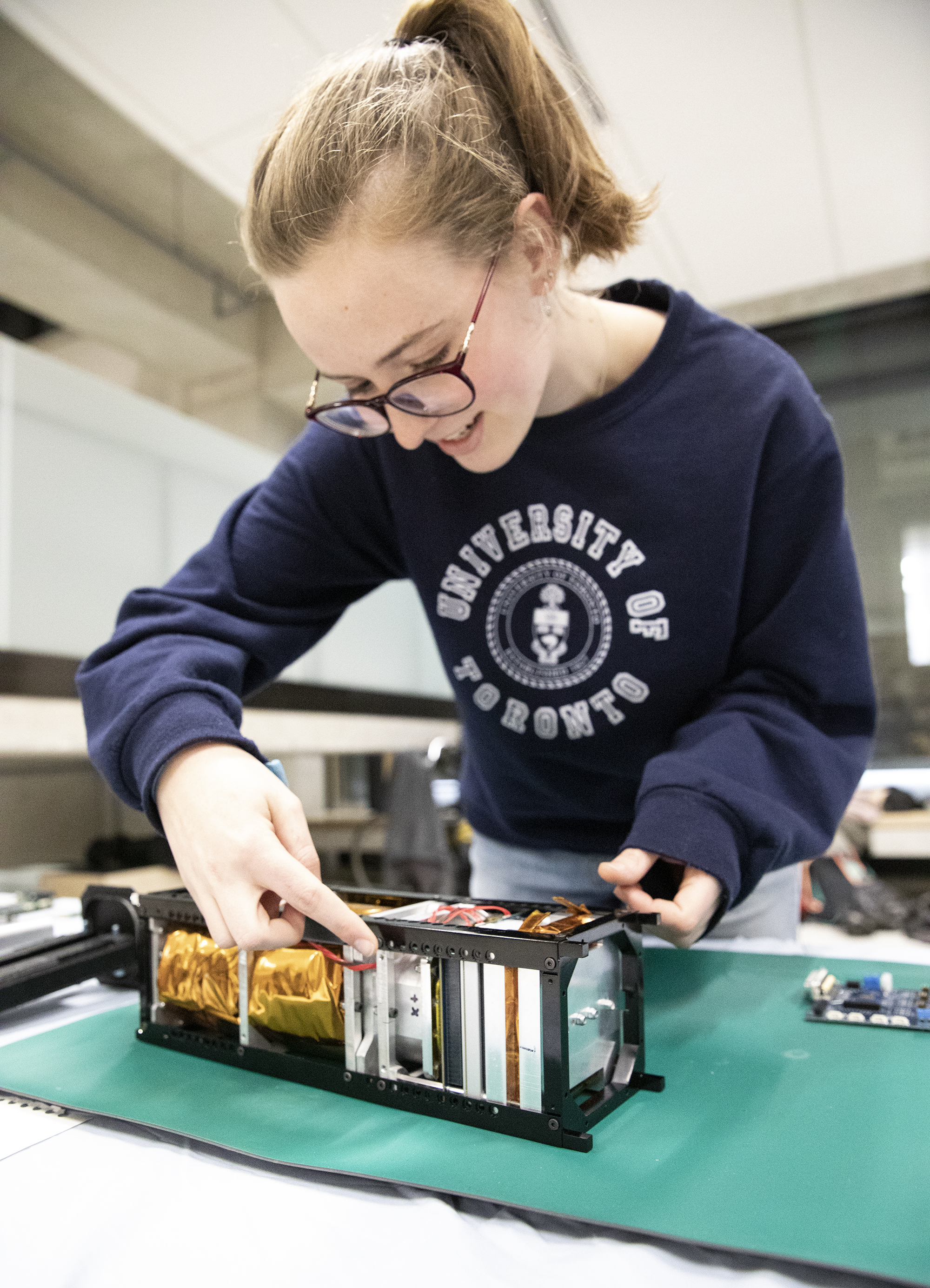 Cassandra Chanen (Year 2 EngSci) shows off the Heron MK II, a cubesat that will take a microbiology payload to space. (Credit: Erica Rae Chong)