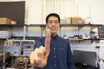 MASc student Tianqi Xu holds up a microrobot that was fabricated using their automated system. (Photo credit: Liz Do)