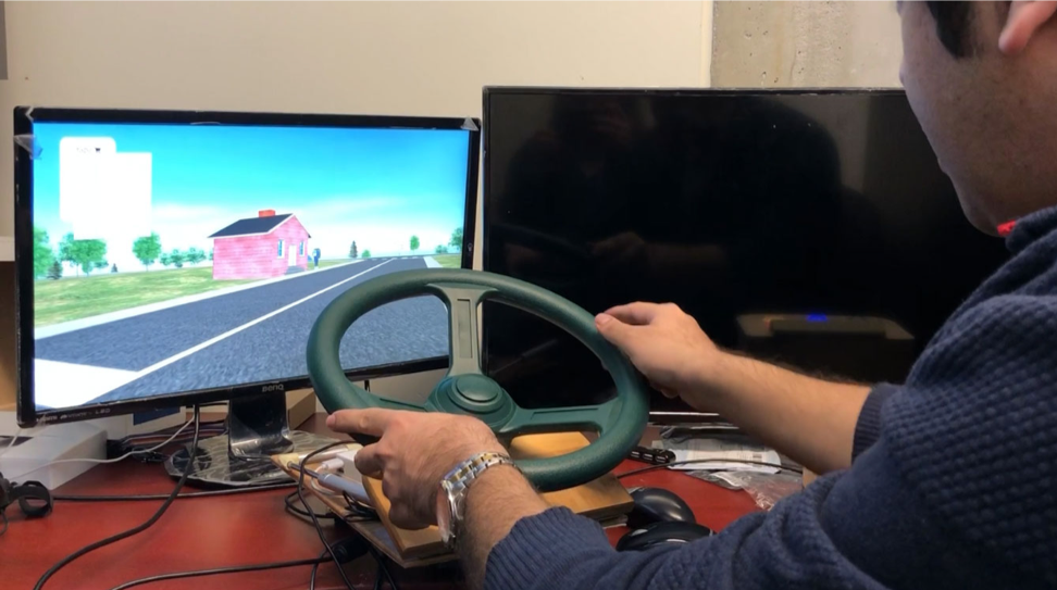 Postdoctoral fellow Farzad Nejatimoharrami demonstrates the driving simulator in Professor Chignell’s lab (Photo: Pam Walls).