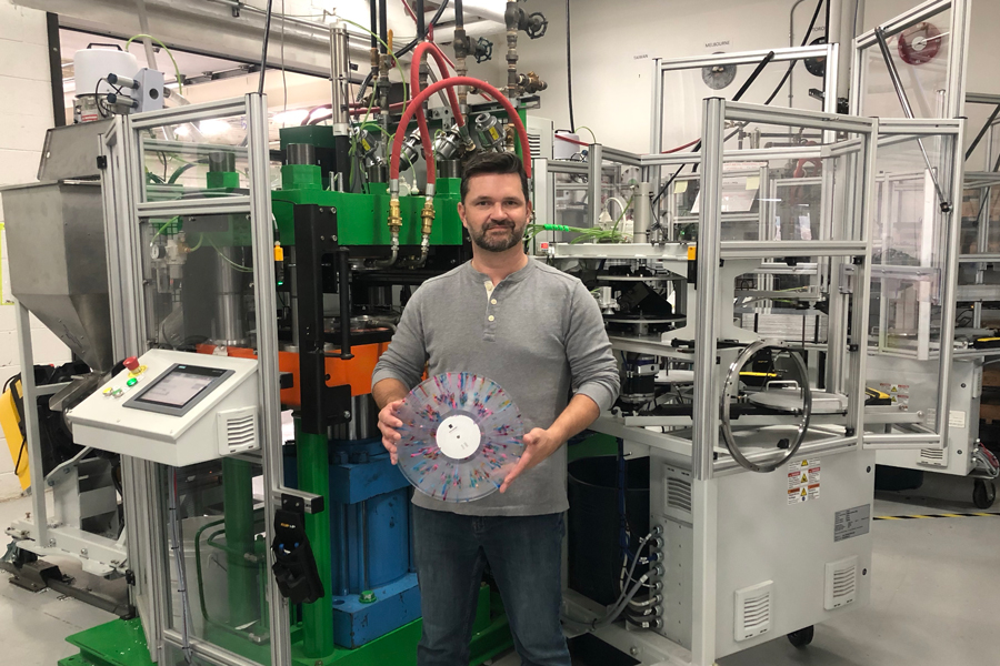 Rob Brown (MechE 0T0), chief operating officer of Viryl Technologies, holds up a “splatter” record made on the company’s LiteTone vinyl press. Viryl Technologies is one of only two firms worldwide that produce such machines. (Photo: Doug Chappell)