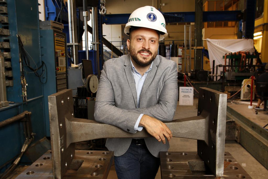 CivE PhD Candidate Pedram Mortazavi, MASc, P.Eng, poses with a cast steel link in the Structures Lab at the University of Toronto’s Department of Civil & Mineral Engineering. Photo: Phill Snel, Department of Civil & Mineral Engineering/ U of T