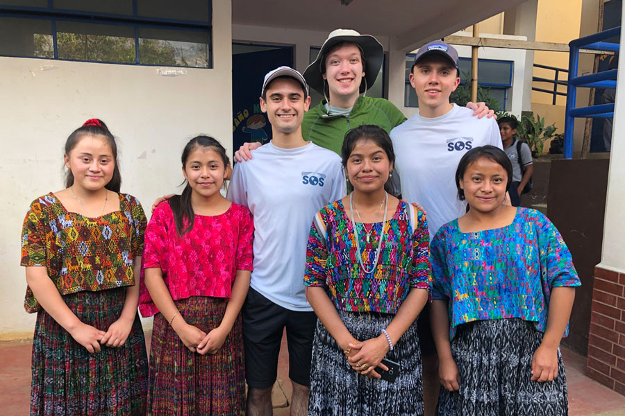 Fourth-year engineering students Kejdi Kola (back left), Calvin Rieder (back middle) and Anton Meier (back right) met with community members in Las Arrugas, Guatemala to design a water purification system for the community. (Photo courtesy Kejdi Kola)