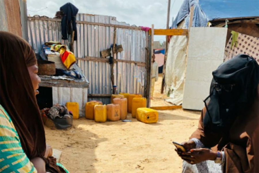 A volunteer uses digital tools created by flatten.ca to collect information on COVID-19 symptoms and spread in Mogadishu, Somalia. (Photo: <a href="https://dsu.so/">Durable Solutions Unit)</a>
