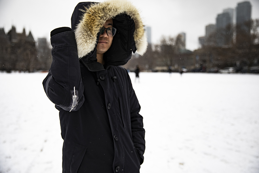 Binbin Ying (MIE) demonstrates the performance of iSkin by sticking it to the outside of his winter jacket, in this photo, taken Feb. 27, 2020, before the COVID-19 pandemic. The cold-tolerant, stretchable, sticky sensor converts physical movement into electrical signals, and can be used in wearable electronics as well as many other applications. (Photo: Runze Zuo)