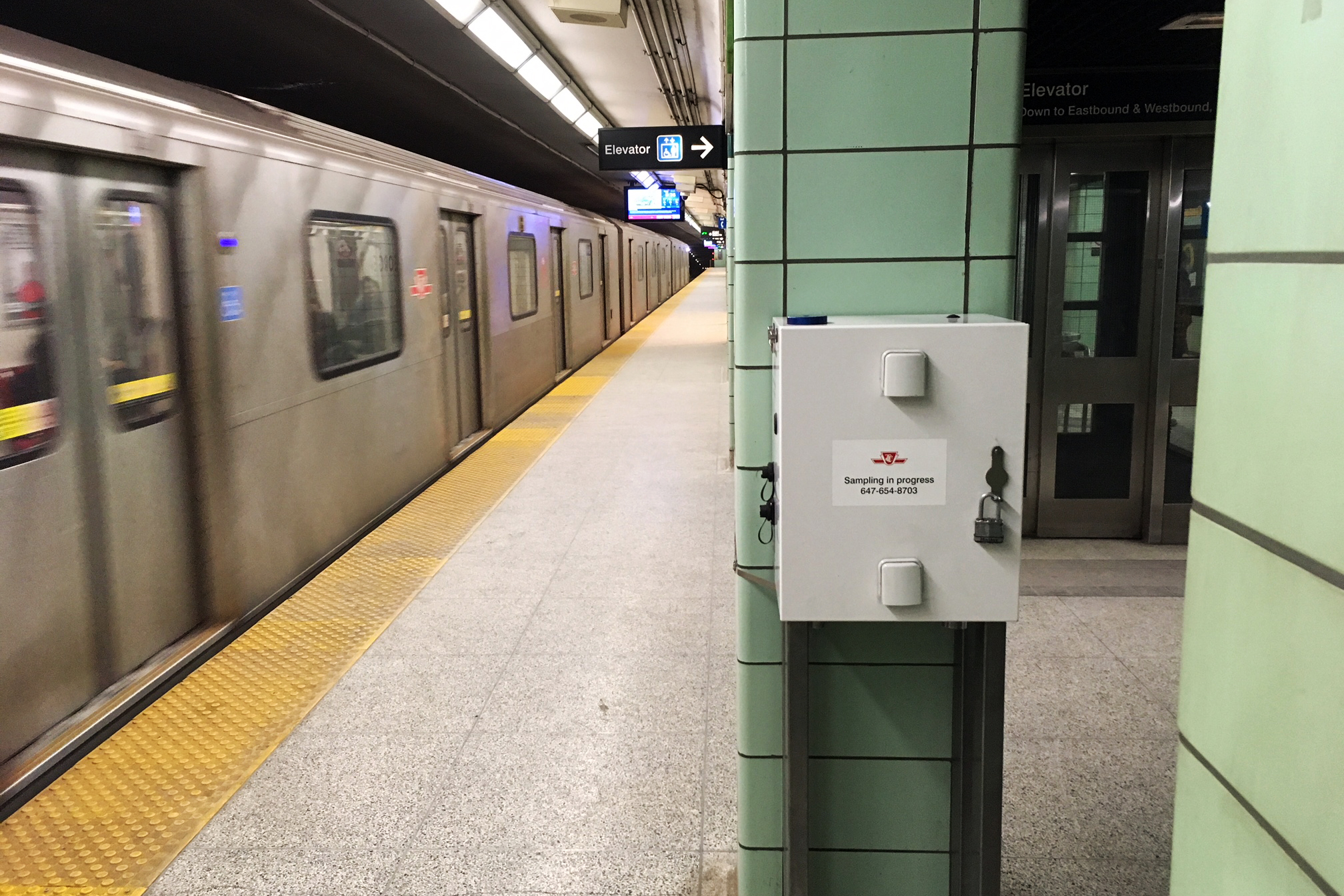 A grey box is seen attached to a pillar on the platform of the Toronto Transit Commission's St. George subway station.