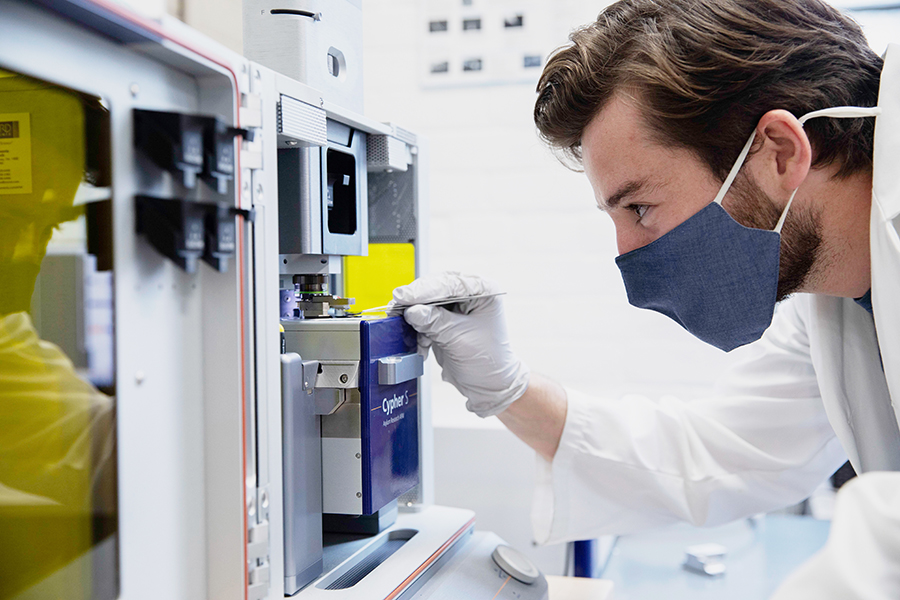 PhD candidate Peter Serles (MIE) places a sample of magnetene in the atomic force microscope. New measurements and simulations of this material show that its low-friction behaviour is due to quantum effects. (Photo: Daria Perevezentsev)