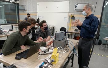 ECE 295 students (from left to right) Adam McDonald, Damian Pacynko and Andrew Moser (all Year 2 ElecE) listen to Professor Sean Hum as the team learns how to automate the use of test and measurement equipment to make a data logger. (Photo: Lihin Karunadhipathi Weera)