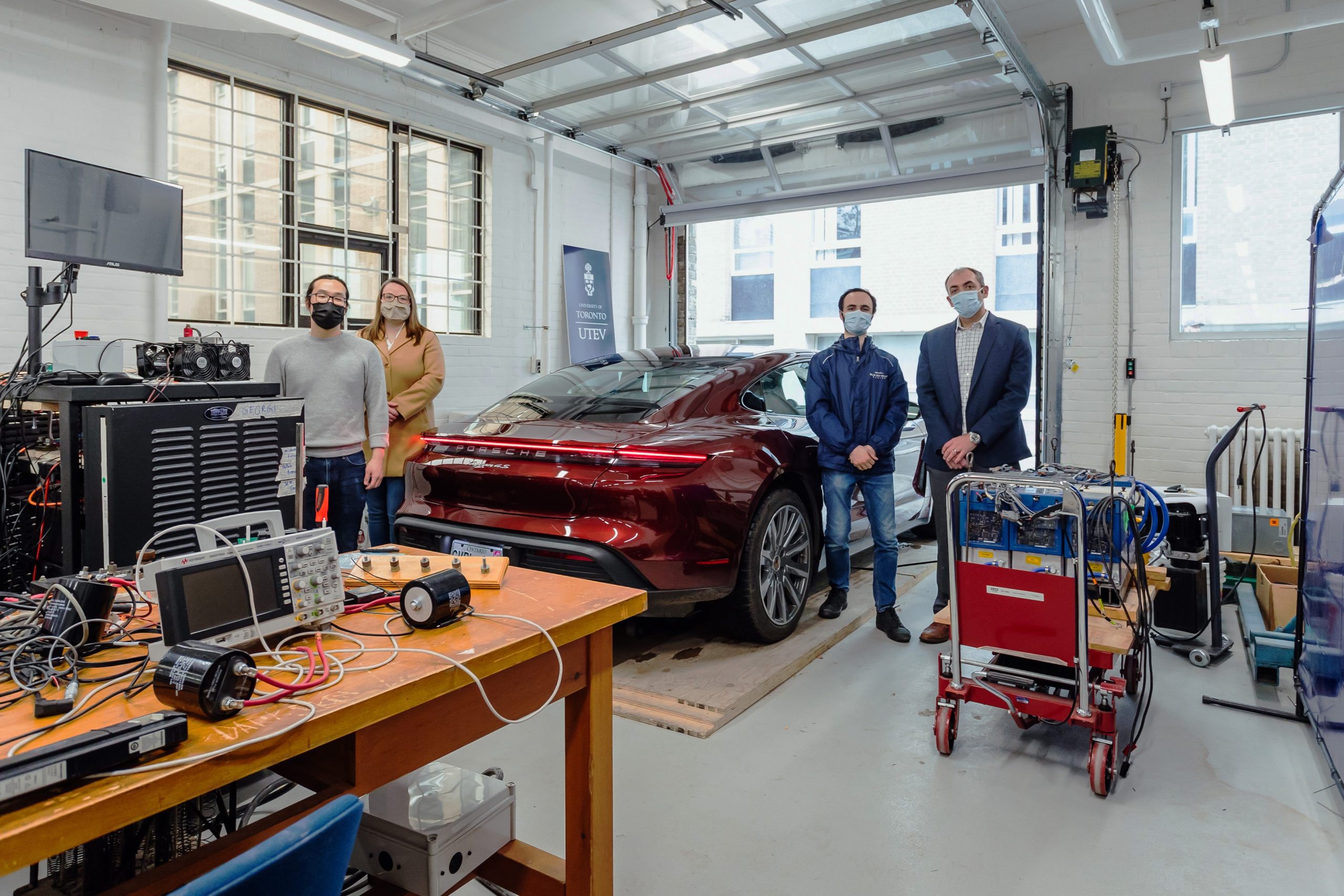 Professor Olivier Trescases (far right) stands in the University of Toronto Electric Vehicle Research Centre with (left to right) PhD Candidate, Zhe Gong; Wendy Baker, Associate Director Business Development, School of Continuing Studies; and Nick Cusimano, Research Associate. Trescases will teach two courses on electric vehicles for Porsche Centre employees. (Photo: Porsche Cars Canada)