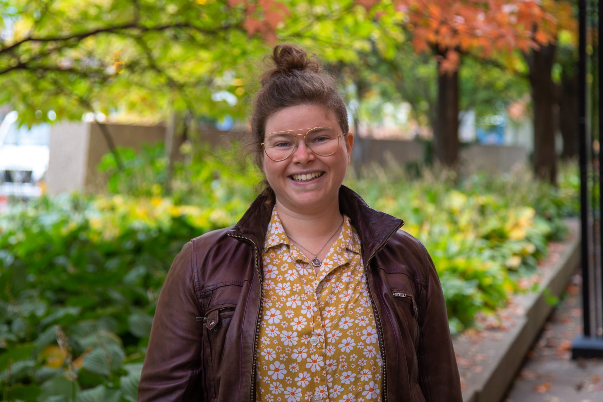 A woman smiles outdoors.