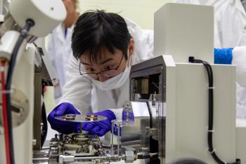 A researcher prepares specimens for analysis under a scanning electron microscope.