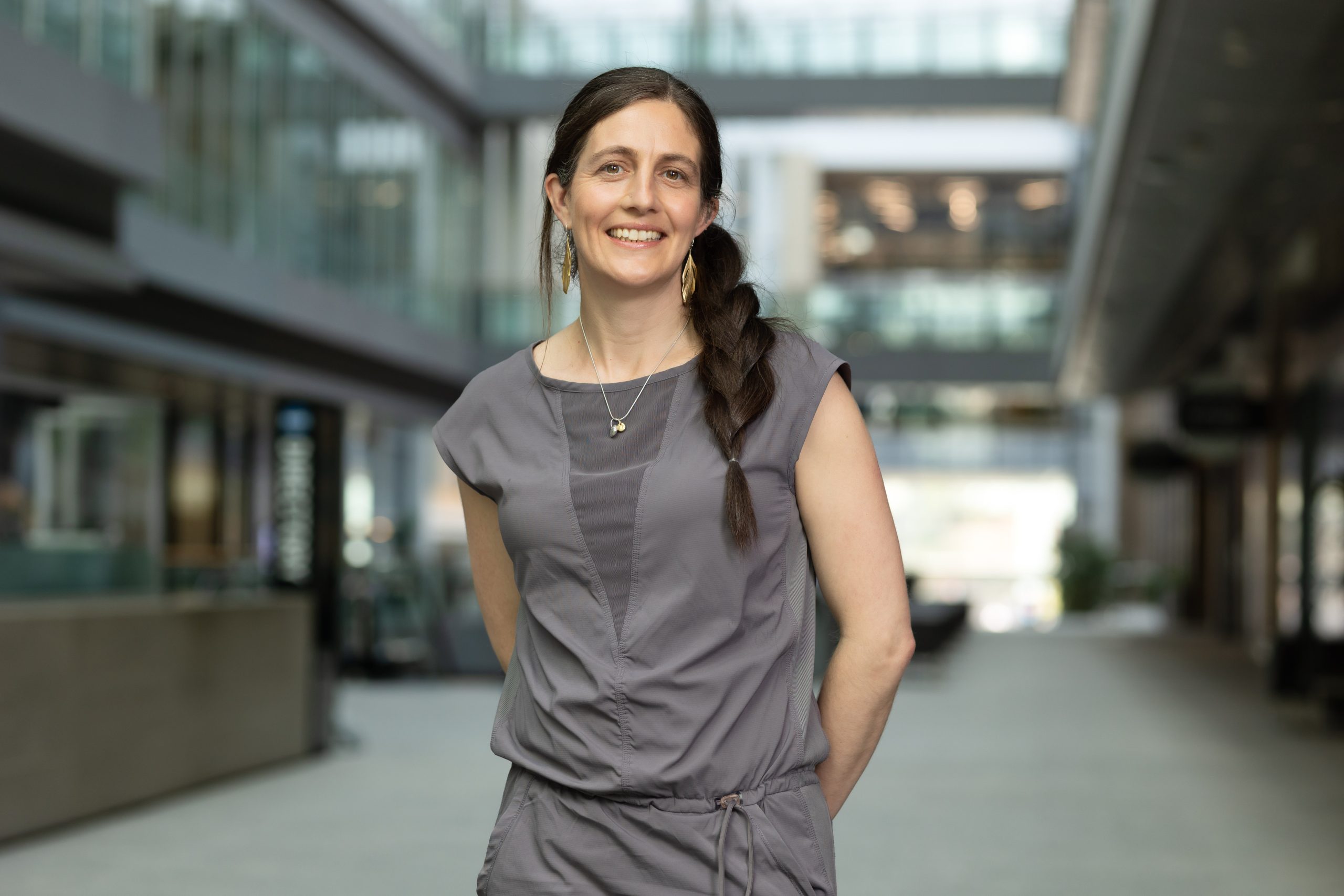 Professor Alison McGuigan stands smiling with her arms behind her back.