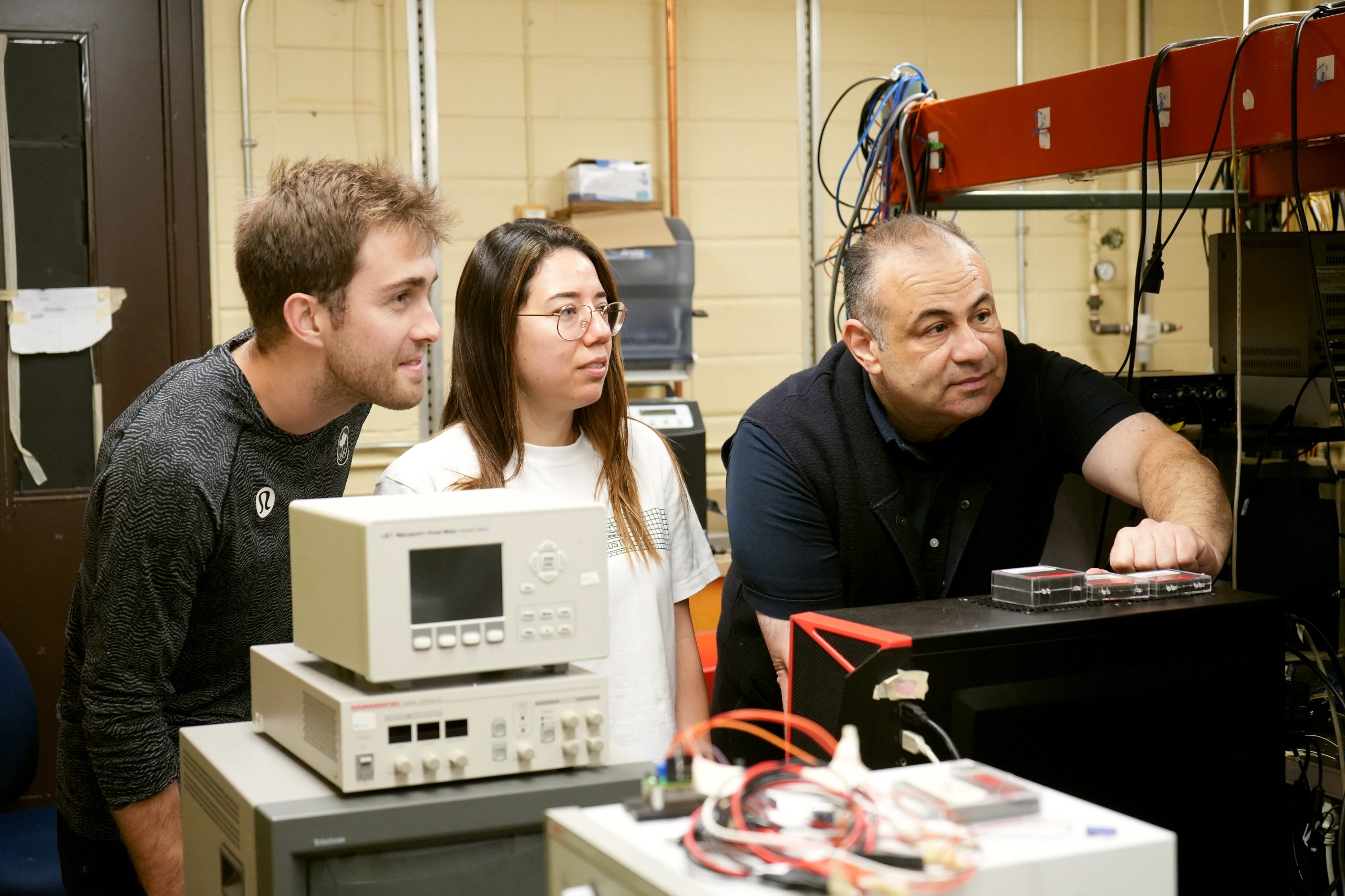 Professor Amr Helmy directing students in a laboratory environment.