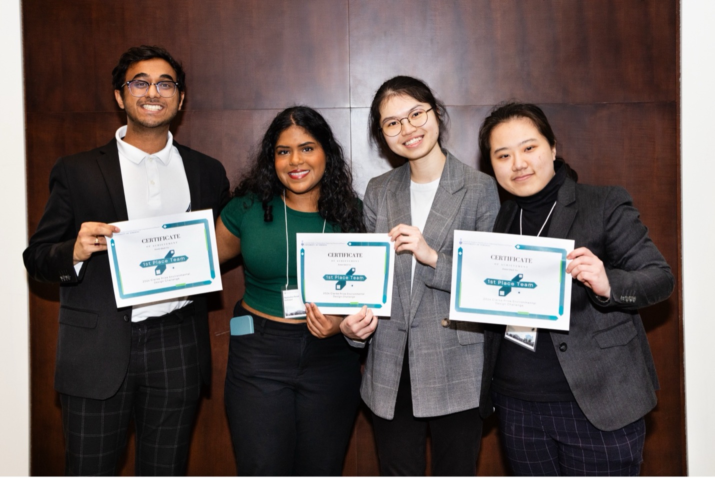 Four students hold up their first place certificates.