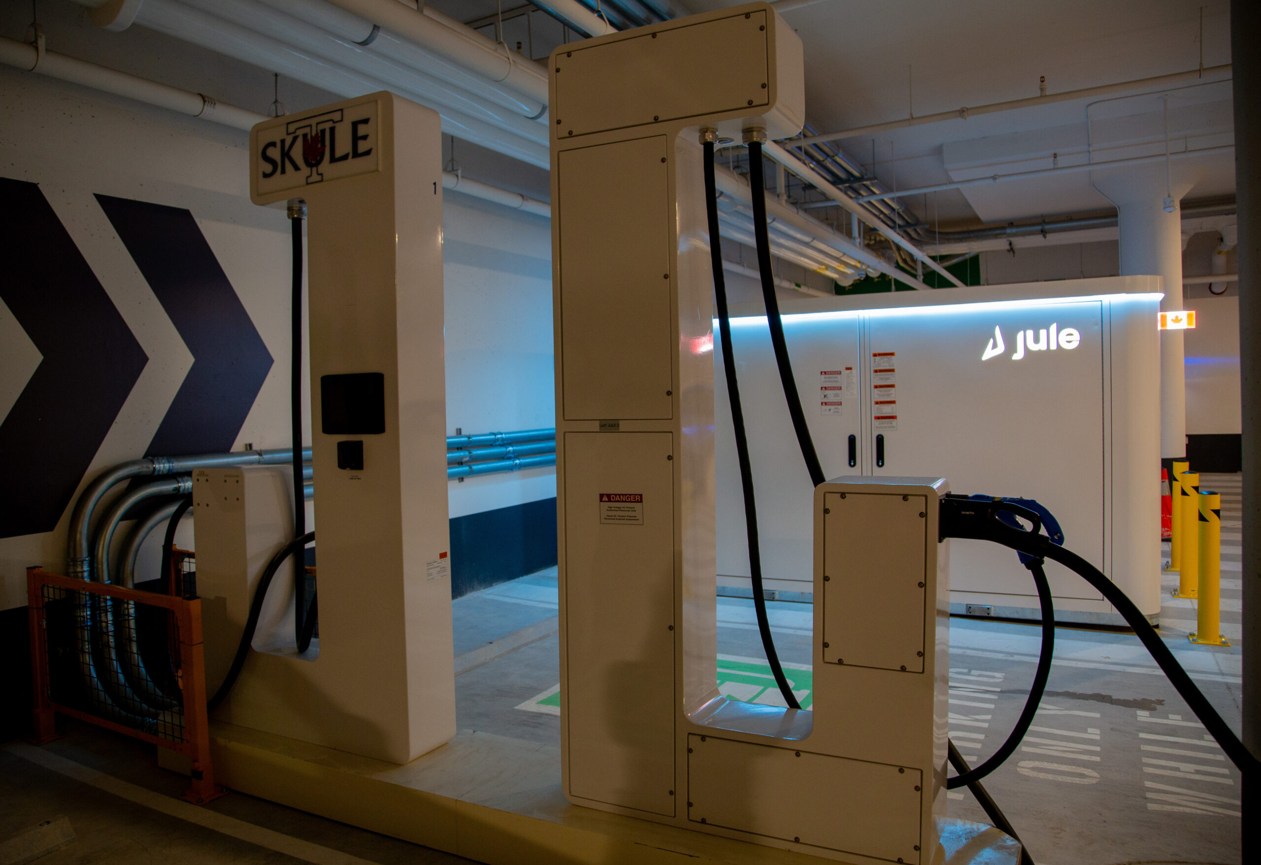 Two of Jule’s Level 3+ DC fast-charging stations are seen in the Landmark Garage at the University of Toronto. The battery energy storage system in visible in the background.