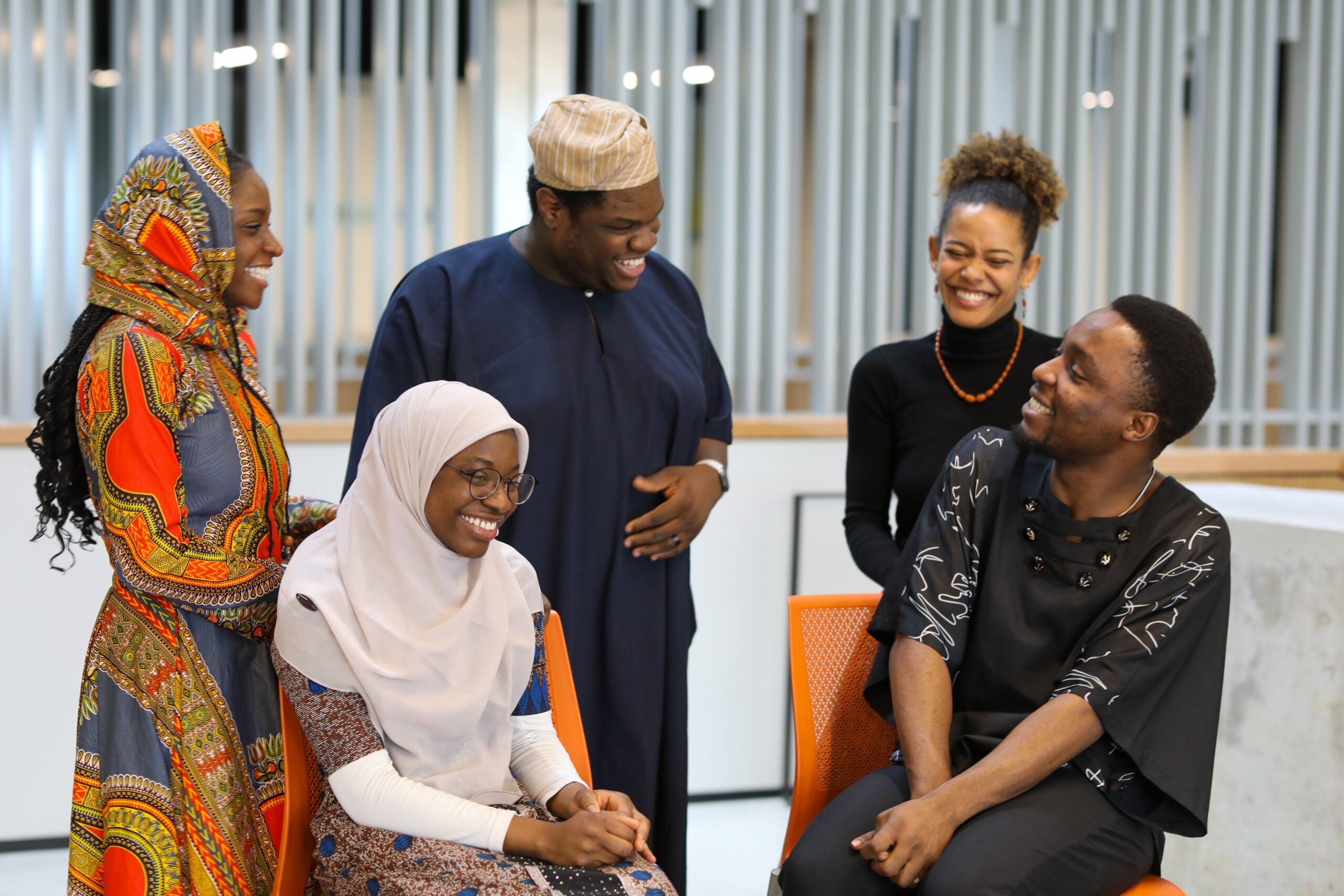 Five members of NSBE Grad laugh together as they share a joke.