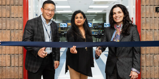 Chris Yip, Deepa Kundur and Marie Hattar, stand before a ribbon. Chris and Marie hold scissors to the ribbon.