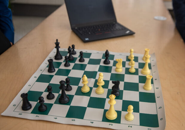 A close up of a chess game depicting a move from the “Game of the Century,” where Bobby Fischer (black) sacrifices his queen in a celebrated brilliant move.
