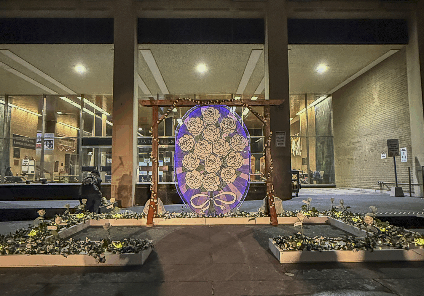 A Dec 6 memorial covered in roses stands infant of the Galbraith building on the U of T campus.