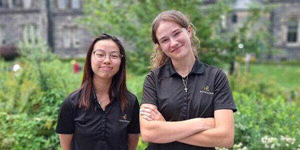 Katie Hung and Anastasia Polulyakhova in front of building on campus.
