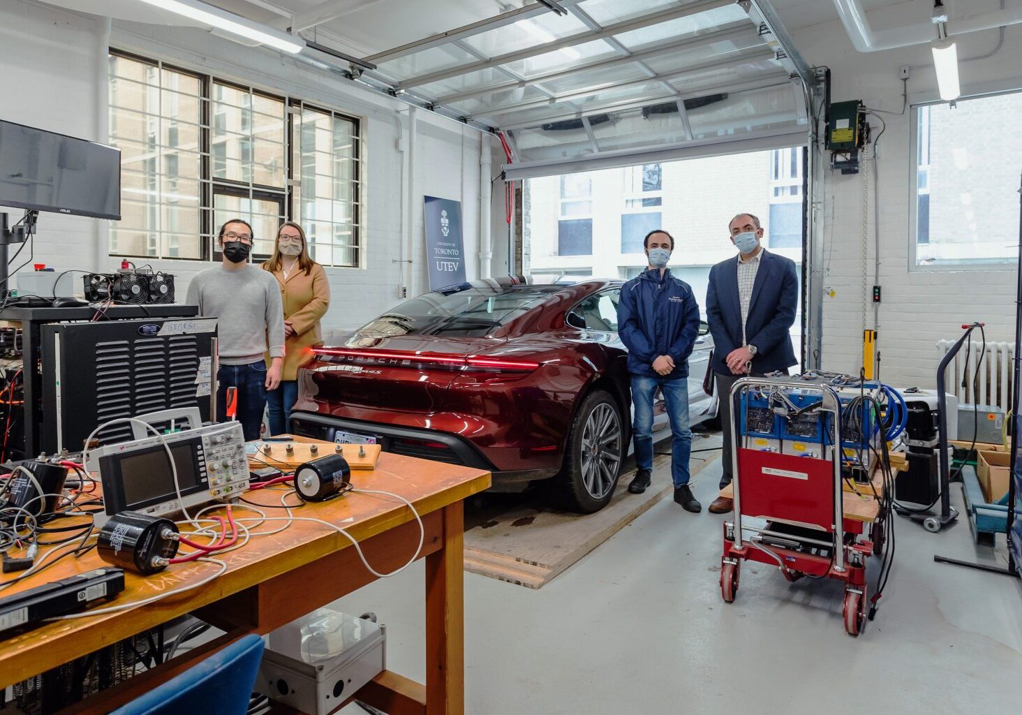 Professor Olivier Trescases (far right) stands in the University of Toronto Electric Vehicle Research Centre with (left to right) PhD Candidate, Zhe Gong; Wendy Baker, Associate Director Business Development, School of Continuing Studies; and Nick Cusimano, Research Associate. Trescases will teach two courses on electric vehicles for Porsche Centre employees. (Photo: Porsche Cars Canada)