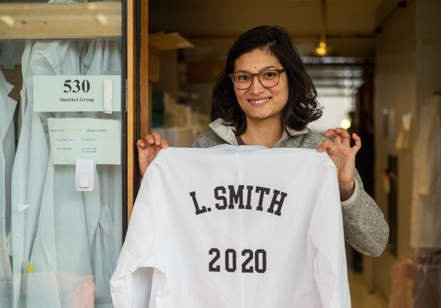 laura-smith Laura Smith, a PhD student in chemical and biomedical engineering, holds up a lab coat bearing her name that will be hung in Molly Shoichet's lab following her graduation next year (photo by Geoffrey Vendeville)